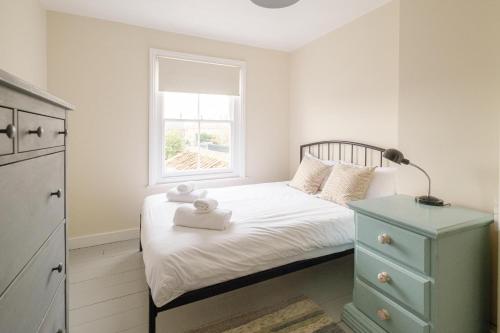 um pequeno quarto com uma cama e uma janela em 41 Eastward Ho em Leiston