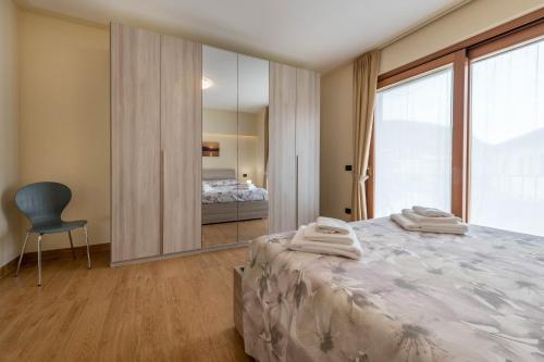 a bedroom with a bed and a chair and a mirror at Passioncasa in Torri del Benaco