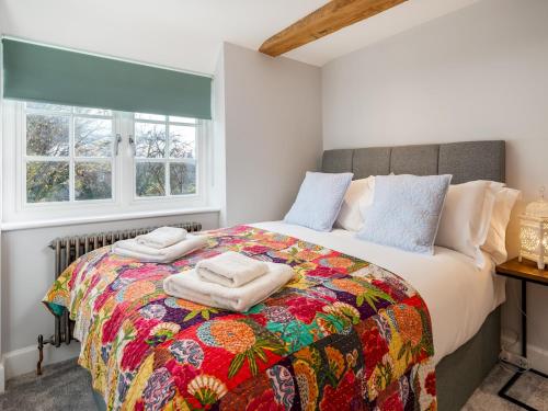 um quarto com uma cama grande e uma colcha colorida em Pass the Keys Converted Hop House Apt - Old Amersham - Chilterns em Amersham