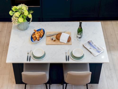 a table with a plate of bread and a bottle of wine at Pass the Keys Converted Hop House Apt - Old Amersham - Chilterns in Amersham