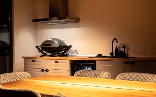 a kitchen with a table with a pot on the counter at Luxury Aframe in Râşnov