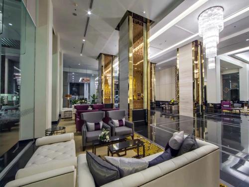 a lobby with couches and tables in a building at Grande Centre Point Ploenchit in Bangkok