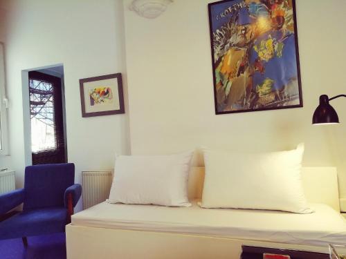 a bed with two pillows and a blue chair in a room at Sacred Way Modern apartment in Athens