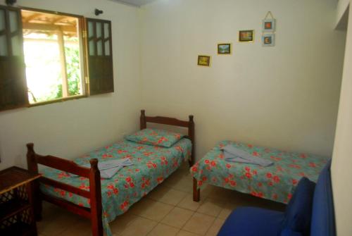a bedroom with two beds and a window at Casa de Dona Rosa in Mata de Sao Joao