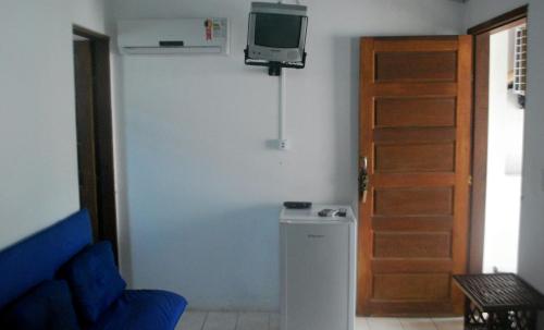 a living room with a tv and a refrigerator at Casa de Dona Rosa in Mata de Sao Joao