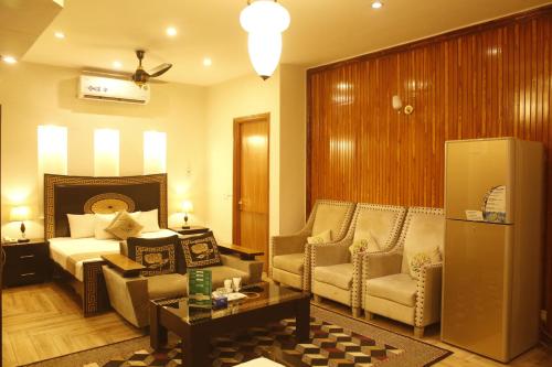a hotel room with a bed and a couch and chairs at Park View Hotel Gulberg in Lahore