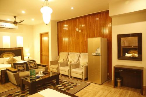 Park View Hotel Gulberg في لاهور: غرفة معيشة مع أريكة وثلاجة
