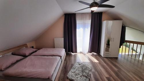 a bedroom with a bed and a ceiling fan at Ferienhaus - a69682 in Heimbach