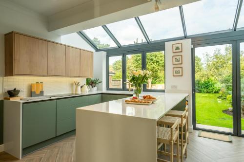 a kitchen with green cabinets and a large window at The Birdie in York