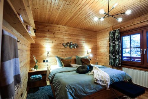 ein Schlafzimmer mit einem Bett in einer Holzhütte in der Unterkunft Bergfreude Chalet in Braunlage