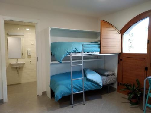 two bunk beds in a room with a sink at Casa de Colònies Casa Pare Coll in Gombreny