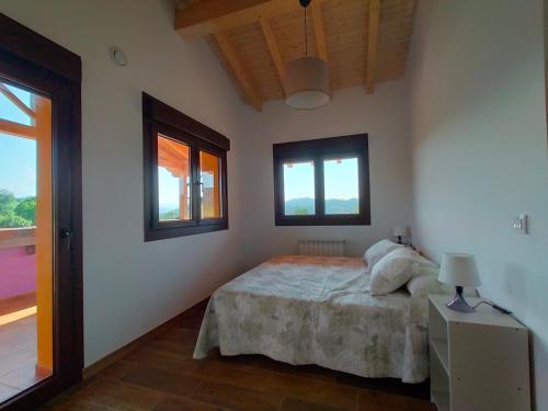 a bedroom with a bed and two windows at PicuAstur in Cangas de Onís