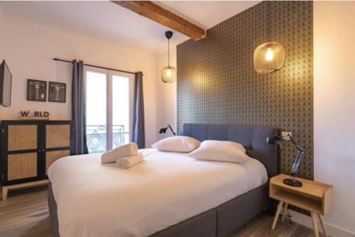 une chambre avec un grand lit blanc et une fenêtre dans l'établissement 1BRE - Splendide appartement Vieux-Port, à Marseille