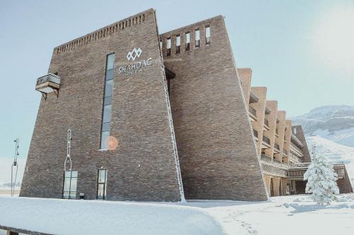 a large brick building in the snow at Shahdag Hotel & Spa in Shahdag
