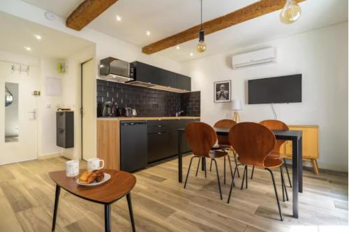 une cuisine et une salle à manger avec une table et des chaises dans l'établissement 1BRE - Splendide appartement Vieux-Port, à Marseille