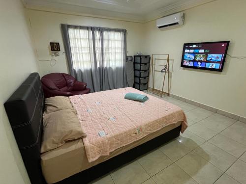 a bedroom with a bed and a flat screen tv at [El Casa] Homestay Miri (8 Pax) in Miri