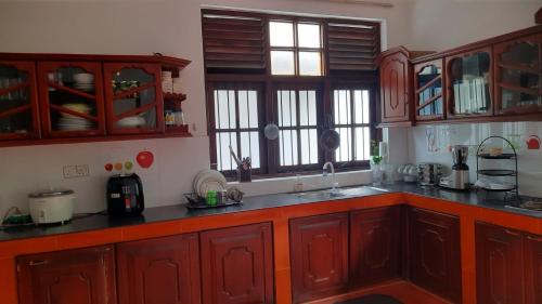 een keuken met houten kasten en een aanrecht bij Party Allowed luxury 4 roomed Furnished house in Jaela in Ja-Ela