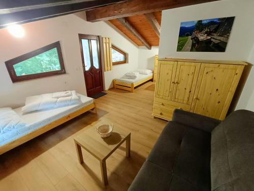 sala de estar con 2 camas y sofá en Britof Forest House in Chestnut Valley en Kanal