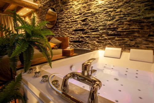 a bathroom with a sink and a stone wall at Love Room Bohème Les Petits Plaisirs in Angers