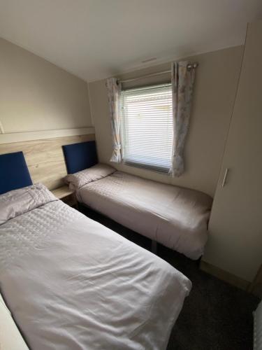 En eller flere senge i et værelse på Meadow View 171 - Golden Palm - Central heating, WiFi, pet friendly, bed linen - Meadow Lakes Caravan & Lodge Hire