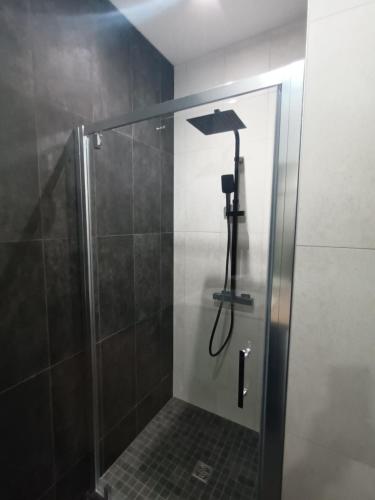 a shower with a glass door in a bathroom at Chez David - T2 neuf dans centre historique in Brioude