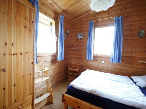 a bedroom with a bed in a wooden cabin at Ferienhaus Nr 20, Typ B, Feriendorf Jägerpark, Bayerischer Wald in Viechtach