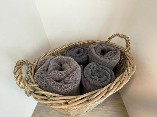 a basket filled with grey towels on a table at Pass the Keys The Cabin Stylish and Elegant for 4 and Furry Friends in Hayfield