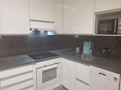 Una cocina con gabinetes blancos y un fregadero. en Apartment in the city center, en Rovaniemi