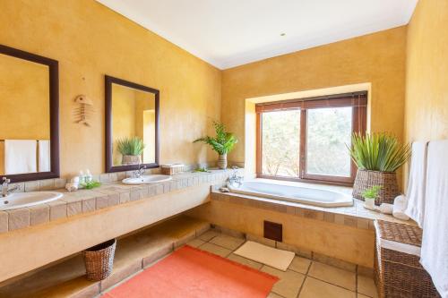a large bathroom with two sinks and a tub at Collection Luxury Accommodation: Quinta Do Sol, Vilanculos, Mozambique in Vilanculos