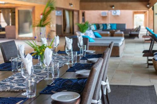 a dining table with chairs and a couch in a living room at Collection Luxury Accommodation: Quinta Do Sol, Vilanculos, Mozambique in Vilanculos