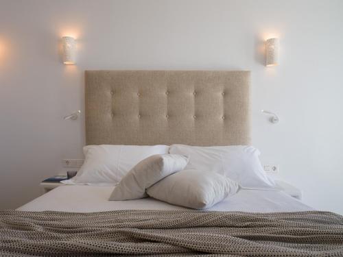 a bed with two pillows on top of it at Arte & Mare Elia Luxury Suites and Villas in Elia Beach