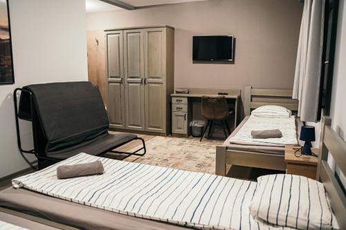 Zimmer mit 2 Betten, einem Stuhl und einem Schreibtisch in der Unterkunft Ride More Activity Center in Miercurea Ciuc