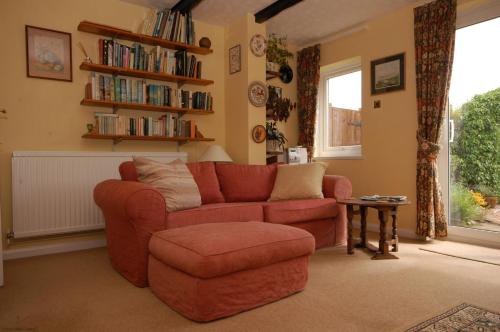 a living room with a red couch and a chair at South Side in West Runton
