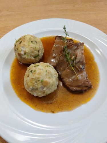 a plate of food with meat and balls of gravy at Pircherhof - Adults Only am Biobauernhof in Pöllau