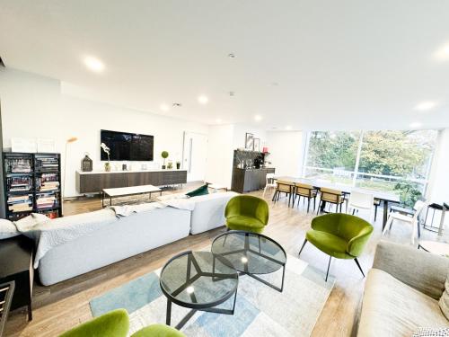 a living room with a white couch and green chairs at Modern 2-Bed Apartment Near Ascot & Legoland, Sleep upto 4 guests, Pet Friendly, Parking Available on Request! in Bracknell
