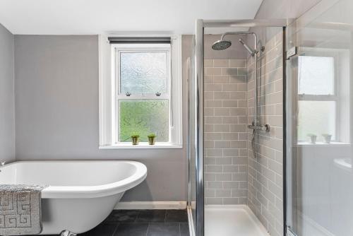 a white bathroom with a tub and a sink at Charming House in Bath - Sleeps 11 in Bath