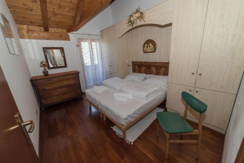 een kleine slaapkamer met een bed en een stoel bij B&B il Ciliegio di Maura in Massimeno