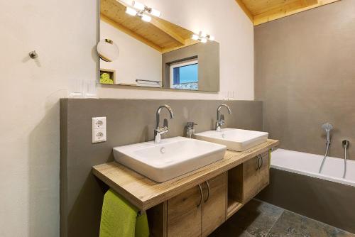 uma casa de banho com 2 lavatórios, um espelho e uma banheira em Ferienwohnungen Bosserthof em Donaueschingen