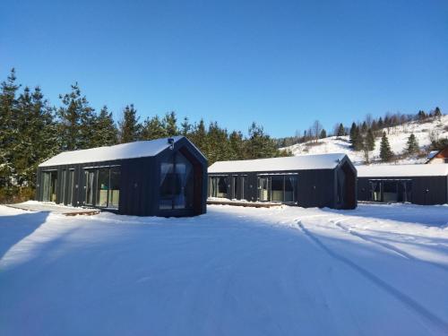 a couple of buildings in the snow at Chyża Zagroda in Jaworki