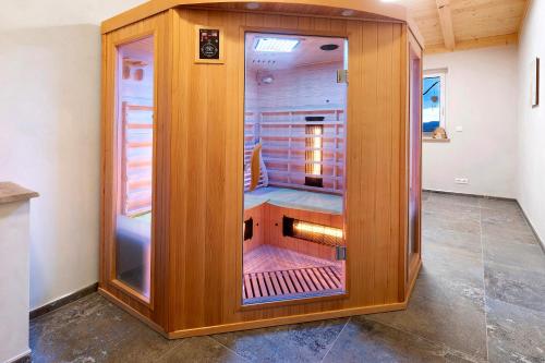 a large wooden cabinet with a glass door in a room at Ferienwohnungen Bosserthof in Donaueschingen