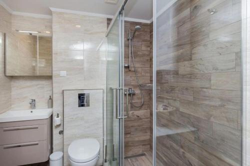 a bathroom with a shower with a toilet and a sink at Leo Apartment in Dubrovnik