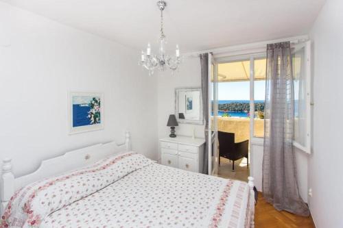een slaapkamer met een bed, een bureau en een raam bij Leo Apartment in Dubrovnik
