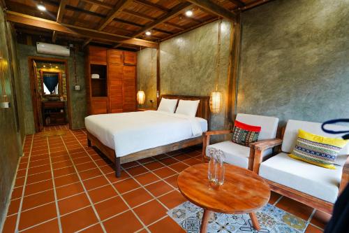 a bedroom with a bed and a table and chairs at Ba Be Jungle Houses in Ba Be