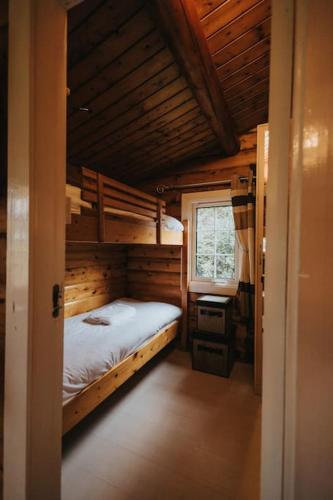a small room with a bed and a window at Rustic Log Cabin in Snowdonia - 2 Bedrooms & Parking in Ffestiniog