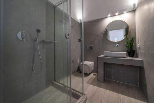 a bathroom with a shower and a sink and a mirror at Nostos Apartments Fira in Fira