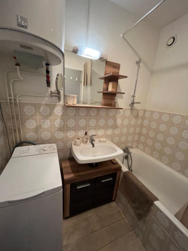 a small bathroom with a sink and a bath tub at T3 La Grande Chaume Le Sauze in Enchastrayes