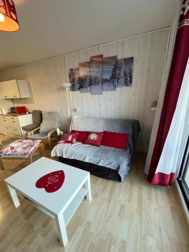 ein Wohnzimmer mit einem Sofa und einem Tisch in der Unterkunft T3 La Grande Chaume Le Sauze in Enchastrayes