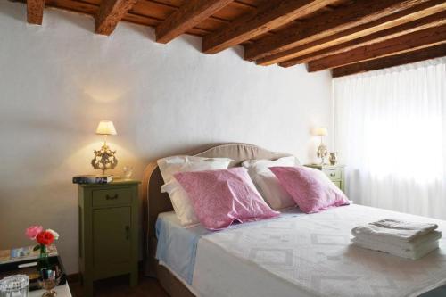 a bedroom with a bed with pink and white pillows at Villa Angiolina in Višnjan