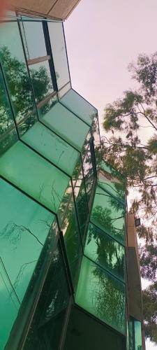 a reflection of trees in a glass building at Park View Hotel Gulberg in Lahore