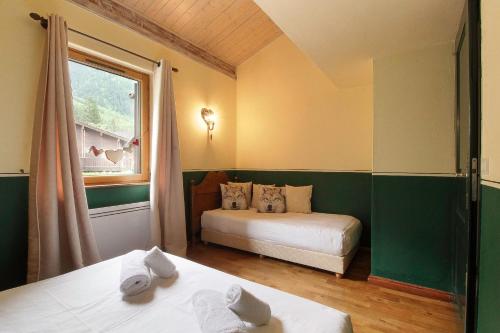 Cette chambre comprend deux lits, une fenêtre et un lit. dans l'établissement Clos des vorgeats 3 - Téléphérique, Terrain de Folf, Randonnée et Bus à la porte, à Chamonix-Mont-Blanc